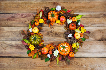 Thanksgiving wreath with pumpkins, yellow roses and white flowers, top view
