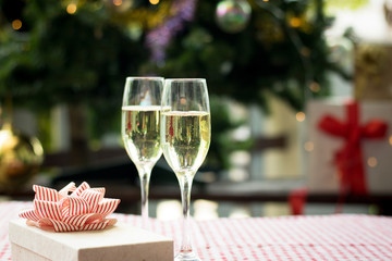 Christmas party drinking concept, glass of champagne with gift box on bokeh background .