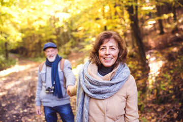 Senior couple on a walk in autumn forest.