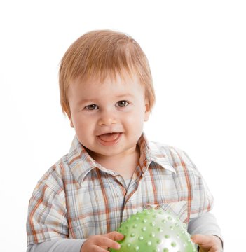 Baby looking at camera holding ball