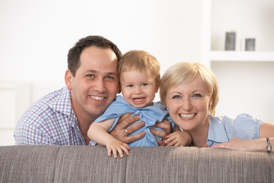 Happy family smiling at camera at home