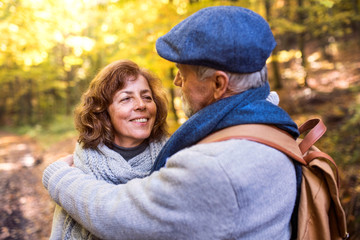 Fototapeta premium Senior couple on a walk in autumn forest.