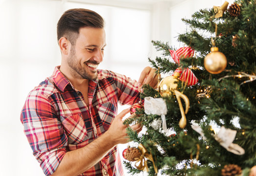 Man Decorating A Christmas Tree