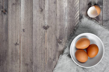 Wooden background with fresh raw eggs