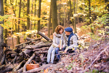 Senior couple on a walk in autumn forest.