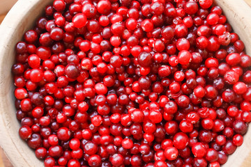 Red berries close-up. Top view of red berries in a wooden bowl