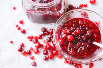 Jam bank with berries top view on a white tablecloth