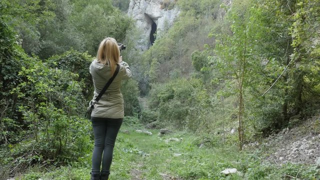 Female hiker takes pictures under natural stone bridge Female hiker takes pictures under natural stone bridge 4K
