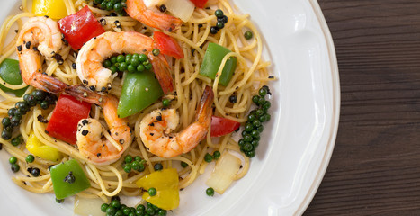 Spaghetti and Prawns Stir with Black pepper sauce delicious Thai food in white dish on dark background