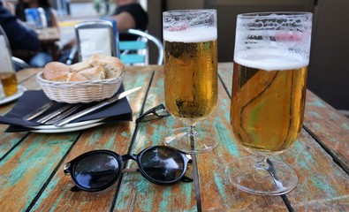 Sunglasses on table with beer