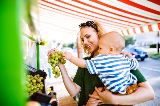 Young Mother With Her Baby Boy At Outdoor Market.