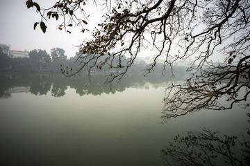 Tree branches over lake landscape in winter season at Hoan Kiem lake, center of Hanoi