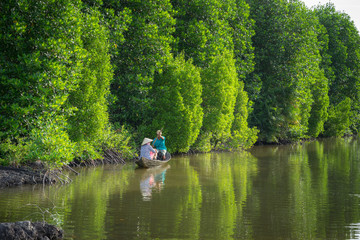 Fototapeta na wymiar Mangrove forest with fishing boat in Ca Mau province, Mekong delta, south of Vietnam