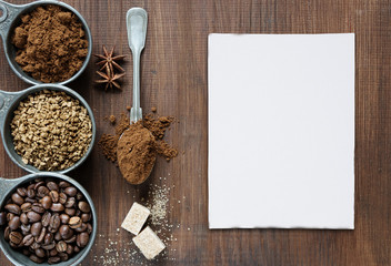 Different types of coffee and white card are on a wooden background