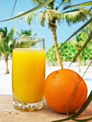 Glass of orange juice on a beach