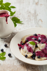 Delicious dumplings with fresh blueberries served with whipped cream and sugar or sauce.