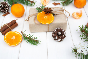 Fototapeta na wymiar Christmas present, cones, mandarins and tree branches
