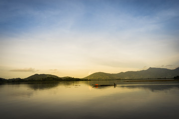Naklejka na ściany i meble Lake with wooden boat at sunset in Vietnam