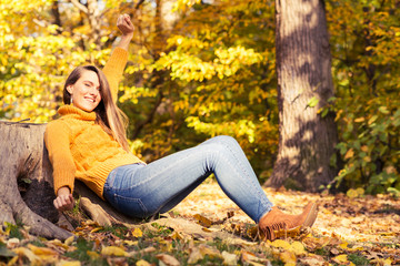 Happy young woman with autumn yellow leaves
