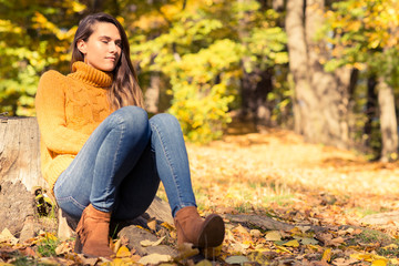 Woman relaxing outside in colorful fall forest