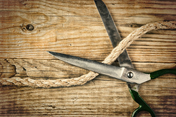 old tailor scissors and rope on the wooden background