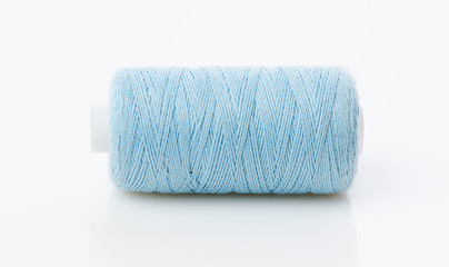 bobbin with blue thread on a white background