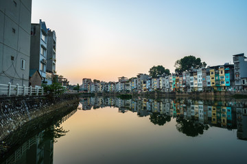 Resident houses and reflection on Tinh Bien lake in Hanoi, Vietnam