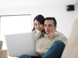 multiethnic couple using laptop computers