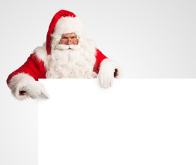 Santa Claus holding a large blank sign  