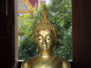 Buddha Face, Image of Buddha. Golden Buddha Statue, beautiful face of Buddha Image with peaceful eyes and smile closeup on background.