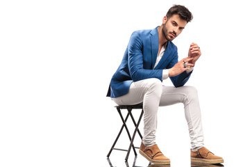 seated fashion man with hands and palms together