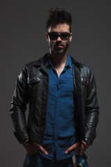 Obraz premium man wearing leather jacket standing with hands in pockets