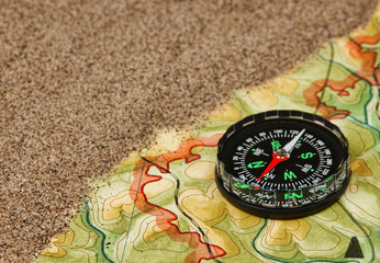 Fototapeta na wymiar compass on the map with sand