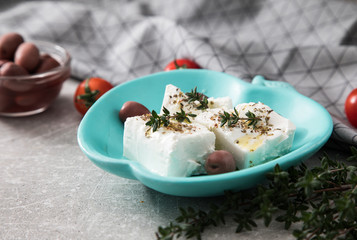 Greek cheese feta with thyme and olives.  selective focus, copy space