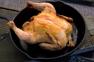 whole roasted chicken and on a wooden background.