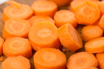 Pile of sliced and chopped carrot on the wooden board