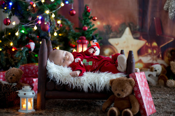 Portrait of newborn baby in Santa clothes in little baby bed