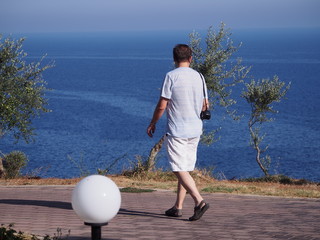 Mężczyzna spacerujący brzegiem morza podczas wakacji