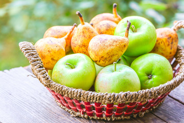 Fruits on wooden table in wicker basket