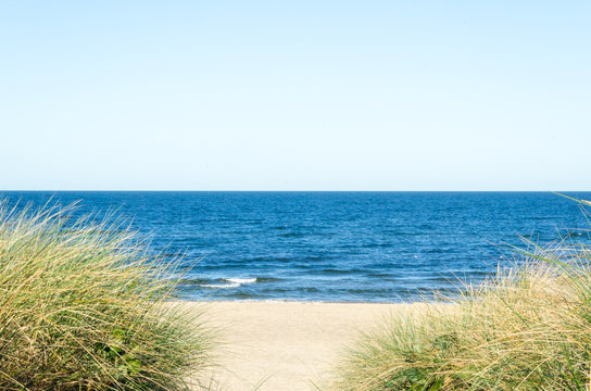 Beach View From The Sand Dunes With Path And Footsteps