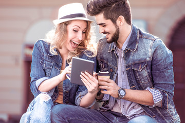 Beautiful young couple enjoying the sun with coffee to go.
