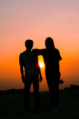 Fototapeta na wymiar Silhouette of a couple standing on sunset.