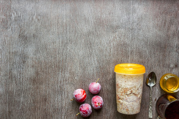 Healthy breakfast with oatmeal in jar and fruit on table