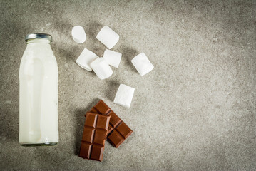 Christmas hot drinks recipes, Set of ingredients for hot chocolate: milk bottle, chocolate, marshmallow. Gray stone background, copy space top view
