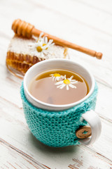 Honeycomb and chamomile tea on white