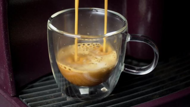 Coffee machine filling a cup with hot  coffee