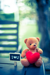 bear doll and red heart and i love you plate on the table with dramatic tone