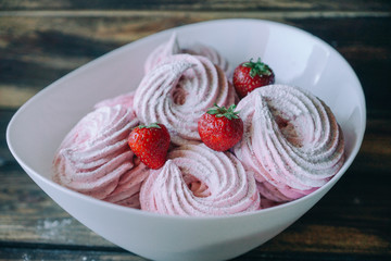 Turkish Beze or Meringues topped with strawberries in a glass bowl. Artwork. Copy space.