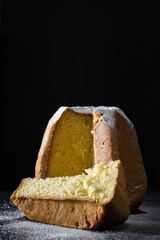Pandoro Christmas cake with sugar on black background