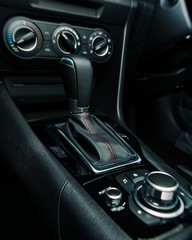 Fototapeta na wymiar Car gear stick, handbrake, air conditioning and music controls